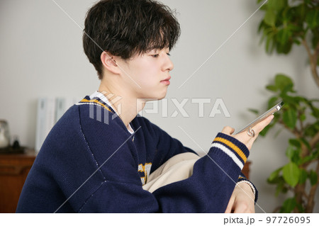 スマホを見る若い男性 スマホを見る若い男性 97726095