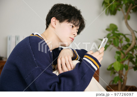 スマホを見る若い男性 97726097