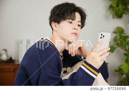 スマホを見る若い男性 スマホを見る若い男性 97726098