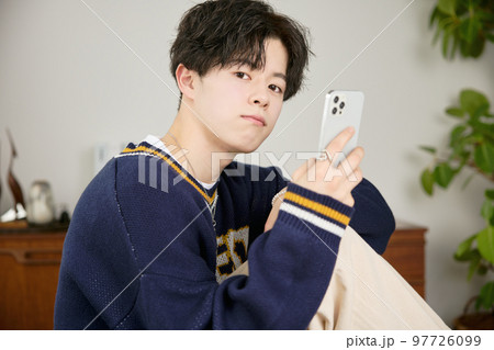スマホを見る若い男性 スマホを見る若い男性 97726099