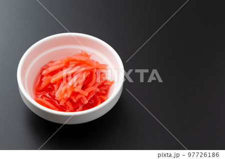 小皿に盛り付けられた紅生姜 黒背景 小皿に盛り付けられた紅生姜 黒背景 97726186