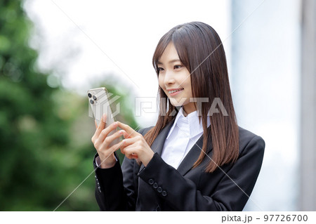 ビジネス　スマホを操作するスーツの女性 97726700