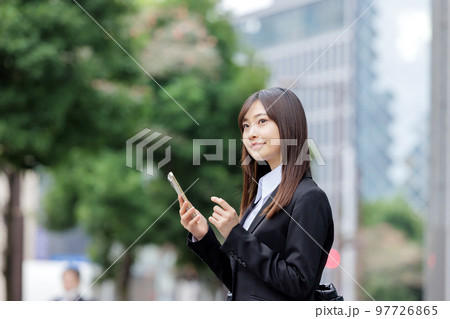 ビジネス スマホを操作するスーツの女性 ビジネス スマホを操作するスーツの女性 97726865