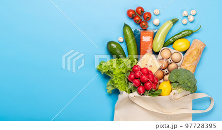 Shopping bag full of healthy food on blue 97728395