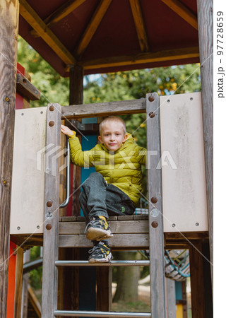 Boy At The Climbing Wall Without A Helmet, Danger At The Climbing Wall. Little Boy Climbing A Rock Wall Indoor Boy At The Climbing Wall Without A Helmet, Danger At The Climbing Wall. Little Boy Climbing A Rock Wall Indoor 97728659
