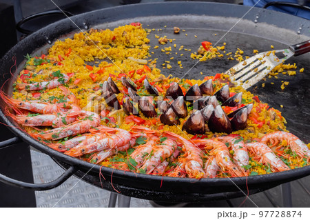 Cooked paella with shrimp, musse, rice at street food festival - closeup 97728874