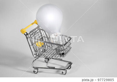 A burning light bulb in a shopping cart. A notion of energy saving 97729805