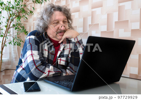 Mature man with laptop and reading specs Mature man with laptop and reading specs 97729929