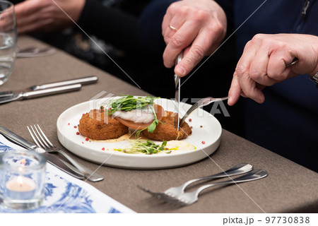 man eating herring with potato Kroket croquette Dutchs favourite snack deep-fried ragout filled snack in a restaurant 97730838