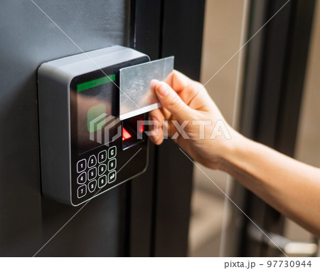 A woman opens the door with a plastic card. Modern keyless entry lock.  97730944