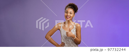 Satisfied good-looking charming african-american woman gladly grinning camera show thumb up pleased like great makeup artist work standing delighted approving recommending nice job, blue background 97732244