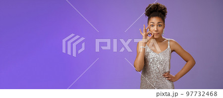 Girl make promise not tell anyone zipping mouth hold hand near pursed lips keep secret safe standing amused excited learn shocking rumor standing blue background gossiping in silver dress 97732468