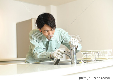 キッチンで伸びる水洗蛇口を点検する作業員 97732896