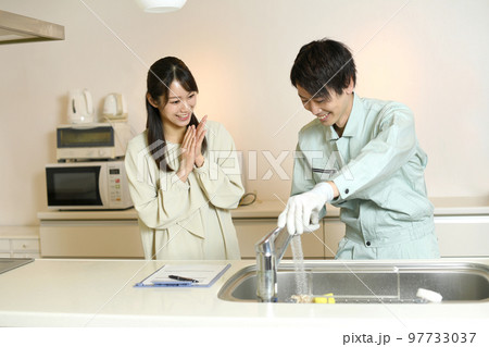 キッチンで会話をする男性作業員と女性客 キッチンで会話をする男性作業員と女性客 97733037