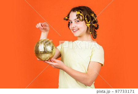 Fashion girl posing in curlers on orange background. saturday night and disco ball. baby shower party. lets have fun on retro party. disco ball decoration. lovely girl with disco ball 97733171