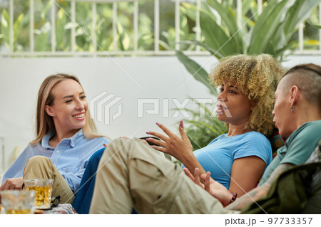Emotional young woman gesturing when telling story to friends at party 97733357