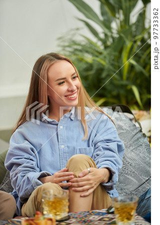 Cheerful young woman listening to story of friends at party 97733362