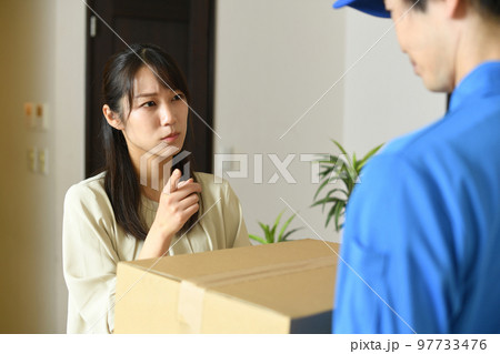 作業着を着た男性とクレームを出す女性客 97733476