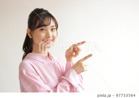 横を指さす若い女性1 97733564