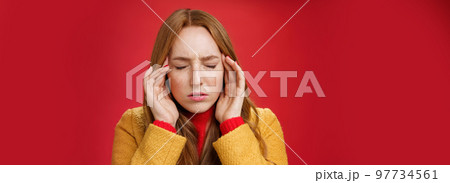 Girl trying keep thoughts together feeling tensed and pressured close eyes frowning rubbing temples, feeling headache or migraine, focusing on thoughts over red background 97734561
