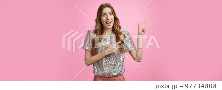 Amused charismatic happy young girl likes shopping see crazy awesome sale scream happily pointing left excited showing you incredible offer, standing impressed thrilled pink background Amused charismatic happy young girl likes shopping see crazy awesome sale scream happily pointing left excited showing you incredible offer, standing impressed thrilled pink background 97734808