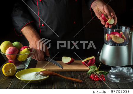 The chef adds apples to the blender to make a fruit drink. Healthy vegetarian breakfast idea 97735053