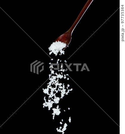 Salt fall, crystal white grain peanuts explode abstract cloud fly from wooden spoon. Beautiful complete seed salt, food object design. Selective focus freeze shot black background isolated 97735364
