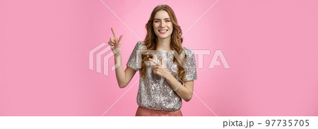 Studio shot friendly-looking joyful smiling pretty european woman curly hairstyle party clothes inviting friends come in pointing upper right corner grinning happily having fun show advertisement Studio shot friendly-looking joyful smiling pretty european woman curly hairstyle party clothes inviting friends come in pointing upper right corner grinning happily having fun show advertisement 97735705