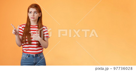 Complicated troubled cute young redhead girl puzzled facing tough difficult decision, look uneasy frowning perplexed hesitating, stare pointing upper left corner disappointed, orange background Complicated troubled cute young redhead girl puzzled facing tough difficult decision, look uneasy frowning perplexed hesitating, stare pointing upper left corner disappointed, orange background 97736028