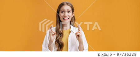 Girl hopes she did well on exam clenching teeth looking worried and concerned, crossing fingers for good luck praying making wish for dream come true waiting with expactation of miracle Girl hopes she did well on exam clenching teeth looking worried and concerned, crossing fingers for good luck praying making wish for dream come true waiting with expactation of miracle 97736228