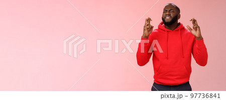 Passionate devoted african-american male fan praying cross fingers good luck asking god win bet biting lip impatiently waiting important results supplicating hopefully, standing pink background Passionate devoted african-american male fan praying cross fingers good luck asking god win bet biting lip impatiently waiting important results supplicating hopefully, standing pink background 97736841