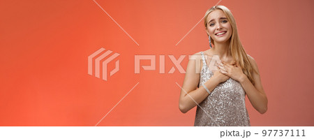 Touched delighted charming blond woman receive heartwarming pleasant gift smiling glad press palms heart moved thanking cherish romantic move boyfriend made, standing red background 97737111