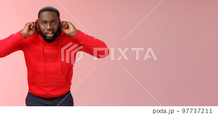 Annoyed funny irritated young african-american bearded guy bending forward close ears plug index fingers grimacing fed up hear loud awful noise repairment works standing bothered lose temper Annoyed funny irritated young african-american bearded guy bending forward close ears plug index fingers grimacing fed up hear loud awful noise repairment works standing bothered lose temper 97737211