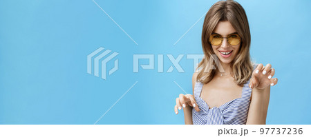 Sensual woman feeling like attractive wild cat raising hands like paws saying meow looking daring and flirty at camera, seducing with confident gaze, wearing stylish sunglasses and striped top Sensual woman feeling like attractive wild cat raising hands like paws saying meow looking daring and flirty at camera, seducing with confident gaze, wearing stylish sunglasses and striped top 97737236
