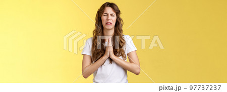 Please beg you. Sobbing timid insecure distressed cute whining girl crying upset close eyes grimacing hold hands pray pleading asking favour apologizing sincere hope for pity yellow background Please beg you. Sobbing timid insecure distressed cute whining girl crying upset close eyes grimacing hold hands pray pleading asking favour apologizing sincere hope for pity yellow background 97737237