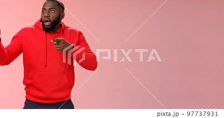 Shocked stunned man widen eyes gasping drop jaw standing stupor pointing look left astonished witnessing terrible breathtaking scene, standing pink background pale freak-out start panic 97737931