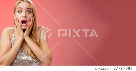 Shocked speechless concerned young stunned woman gasping screaming worried drop jaw touch cheeks widen eyes surprised nervously staring camera troubled afraid, standing red background Shocked speechless concerned young stunned woman gasping screaming worried drop jaw touch cheeks widen eyes surprised nervously staring camera troubled afraid, standing red background 97737999