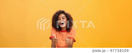 Woman surely knows how boost mood. Portrait of friendly-looking stylish and outgoing african american girlfriend with curly hairstyle showing thumbs up in like and approval agreeing to friend idea 97738109