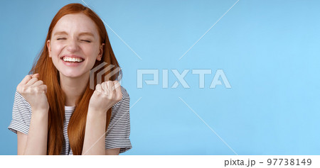 Happy accomplished good-looking ginger girl receive positive results test clench fists rejoicing yelling yes celebrating do winner dance close eyes relieved standing blue background triumphing Happy accomplished good-looking ginger girl receive positive results test clench fists rejoicing yelling yes celebrating do winner dance close eyes relieved standing blue background triumphing 97738149