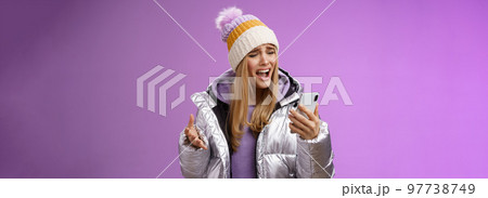 Bothered complaining dissatisfied cute blond girl yelling stupid smartphone standing unhappy recording audio message whining yelling mobile phone upset, standing purple background 97738749