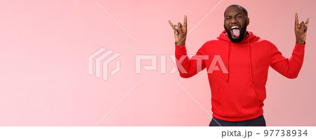 Rebellious outgoing good-looking energized african-american bearded male having fun partying show heavy metal rock-n-roll gesture stick tongue yeah enjoy awesome atmosphere music Rebellious outgoing good-looking energized african-american bearded male having fun partying show heavy metal rock-n-roll gesture stick tongue yeah enjoy awesome atmosphere music 97738934