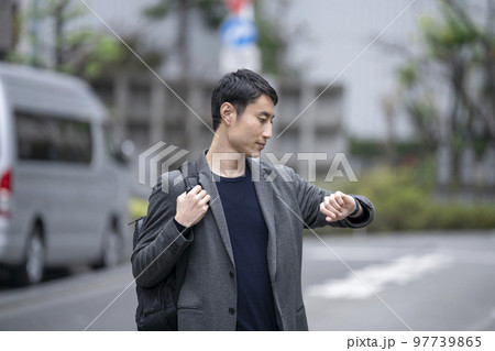 腕時計を見る30代の男性 腕時計を見る30代の男性 97739865
