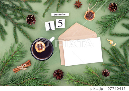December 15. Calendar date, white blank with craft envelope, cup of tea and natural decor on green background. Hello winter. Template for your design, greeting card December 15. Calendar date, white blank with craft envelope, cup of tea and natural decor on green background. Hello winter. Template for your design, greeting card 97740415