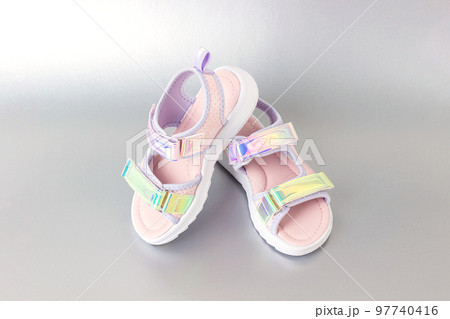 Stylish holographic sandals for kids on grey background. Shiny fashion summer shoes 97740416