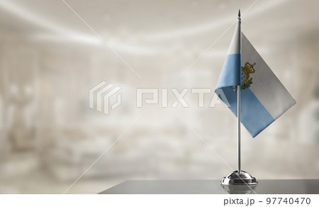 A small San Marino flag on an abstract blurry background 97740470