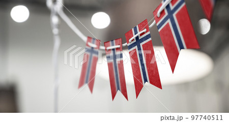 A garland of Norway national flags on an abstract blurred background 97740511