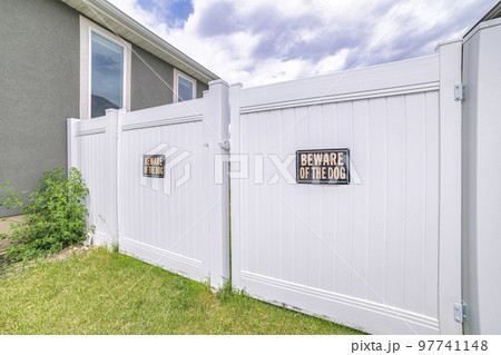 White vinyl fence gate with two beware of dog the signages 97741148