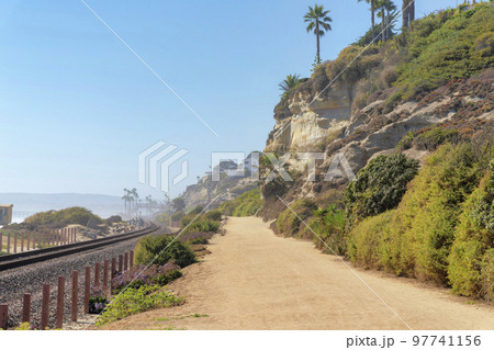 Train track and dirt road at the beach of San Clemente, California 97741156
