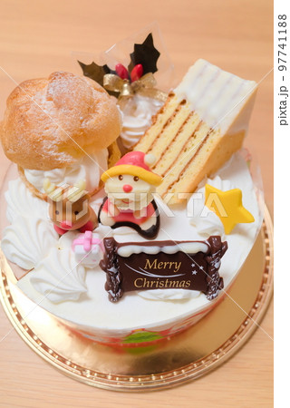 サンタの砂糖菓子やシュークリームが乗った豪華なクリスマスケーキ サンタの砂糖菓子やシュークリームが乗った豪華なクリスマスケーキ 97741188
