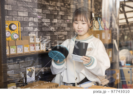 雑貨屋さんて買い物をする若い女性 97743010